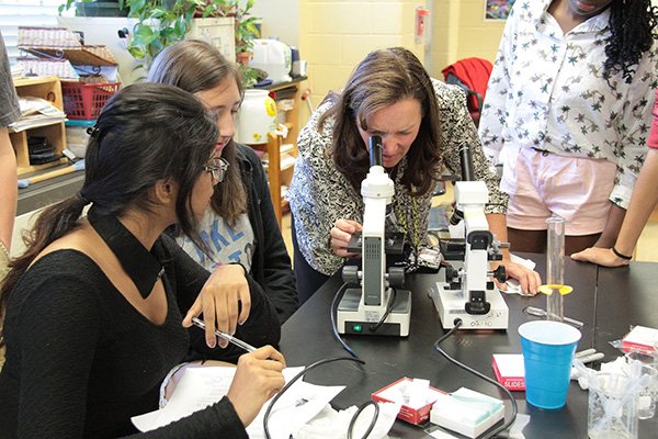 Woman peering into a microscope