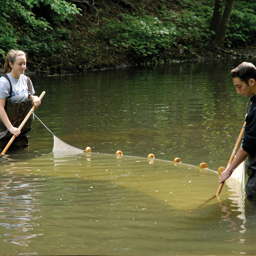 Two young students doing science experiments in river